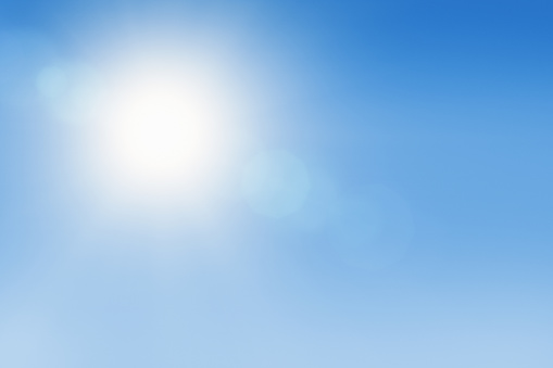 Outdoor background of a white-hot sun overhead in a clear blue sky.
